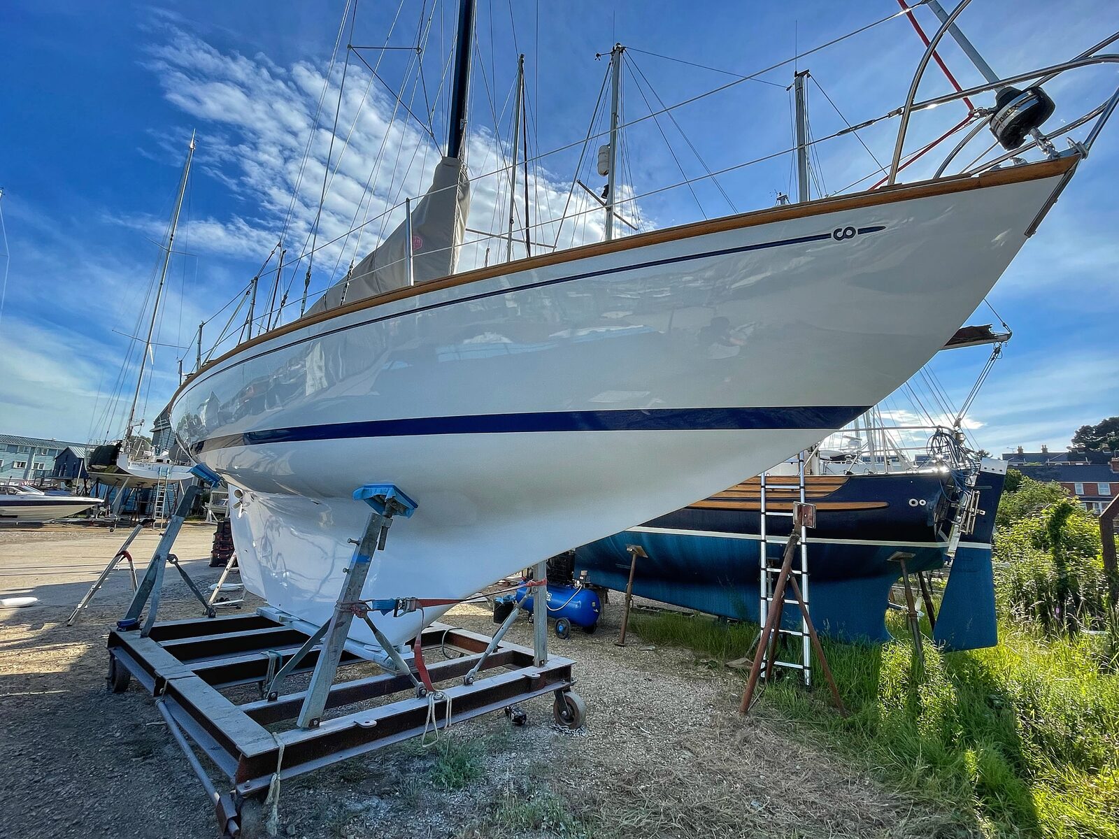 Coated sailboat on stand under a clear blue sky