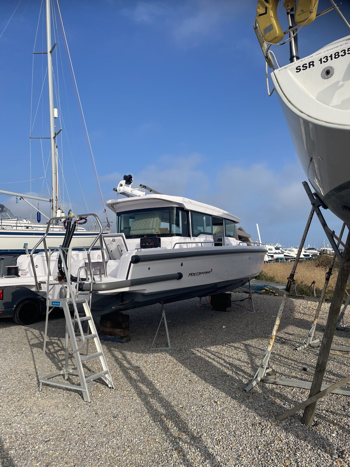 Coated Axopar day boat on hardstand at the marina